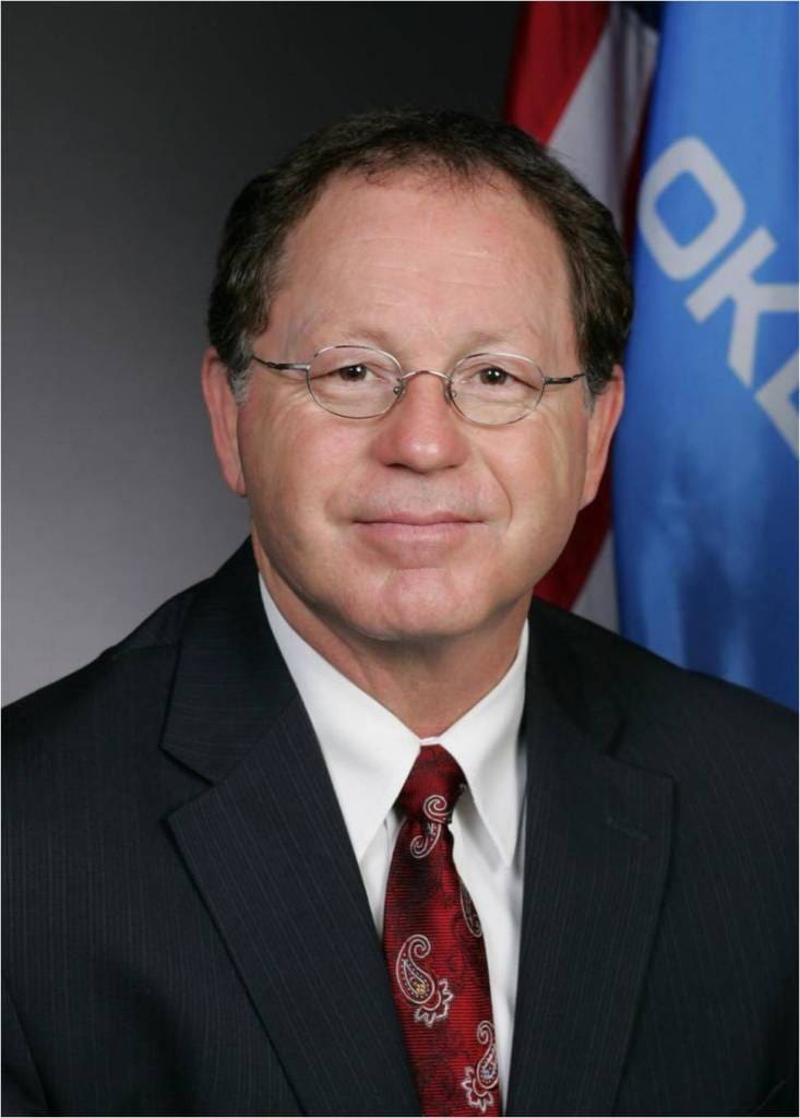 A man in suit and tie with glasses.