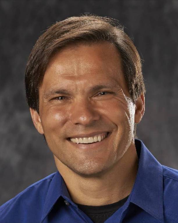 A man with long hair and a blue shirt.