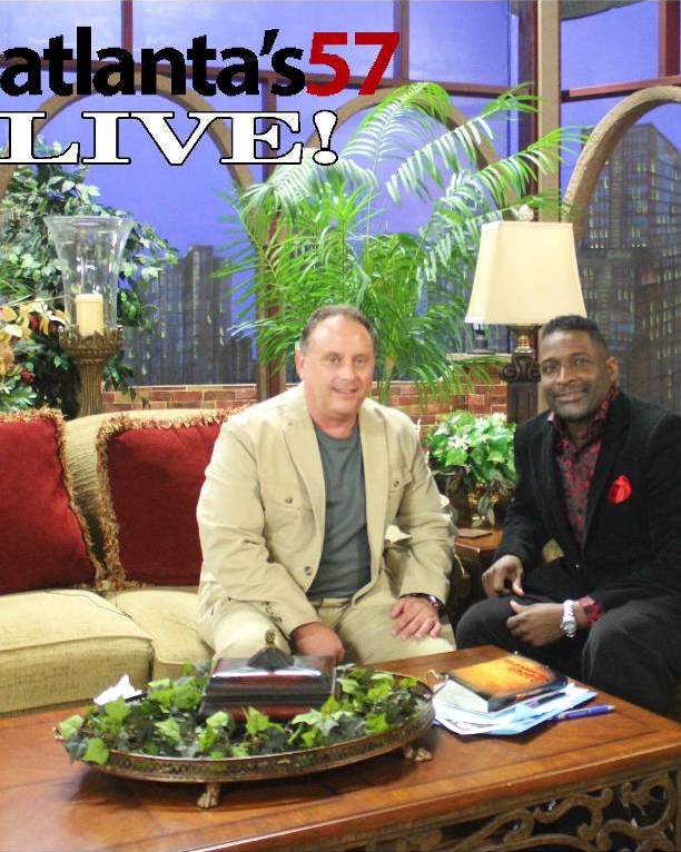 Two men sitting on a couch in front of a tv.