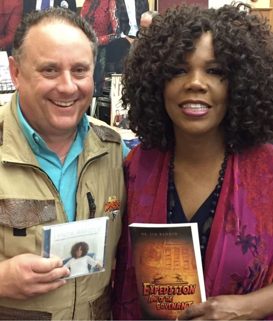 A man and woman holding up books in front of them.